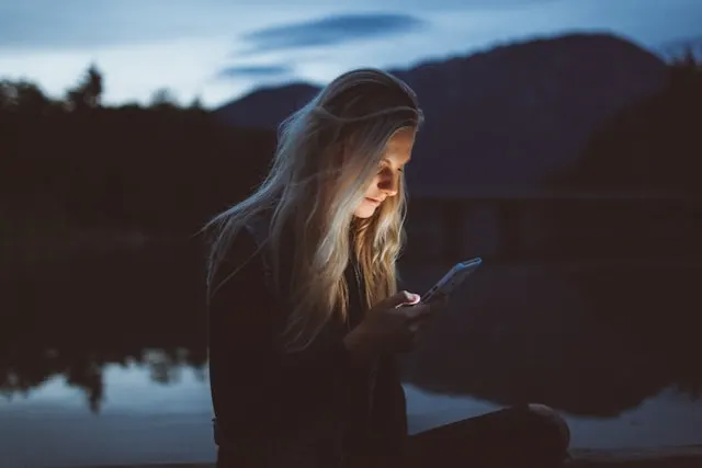A distracted person scrolling on a smartphone, showing the trap of social media popularity vs an official business website.